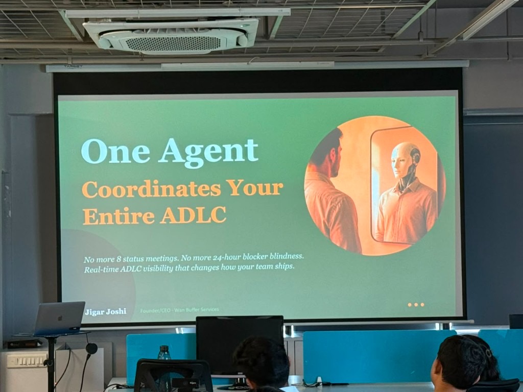 Slide projected on screen: "One Agent Coordinates Your Entire ADLC" — Jigar Joshi at Agile Network India, Ahmedabad