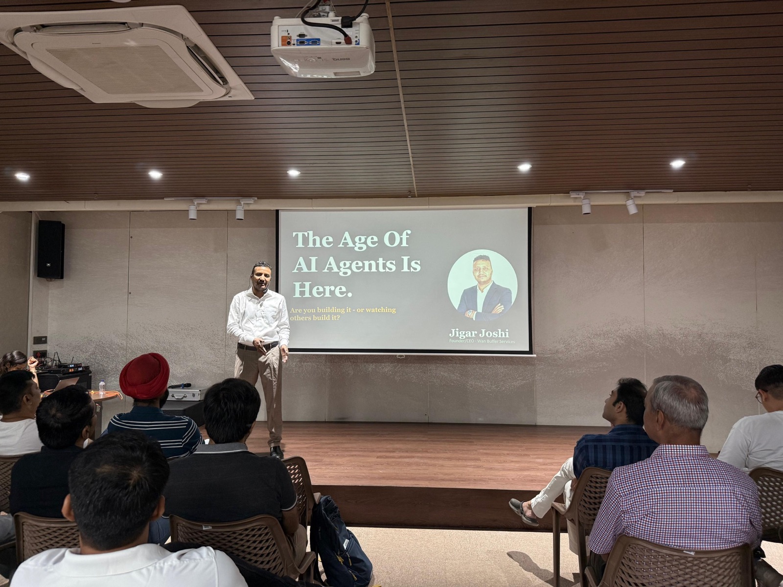 Jigar Joshi standing in front of the slide "The Age Of AI Agents Is Here" at the AIMED workshop in Ahmedabad