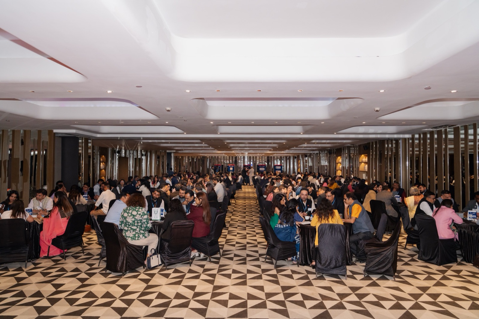 Wide ballroom view of attendees networking in groups at Networkers Mahakumbh 2.0 Business Conclave 2026